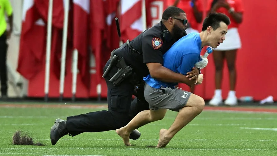 Spectator Intervenes on Field During Houston Cougars Season Opener, Met by Officer's Forceful Tackle